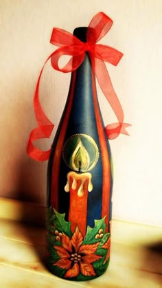 an image of a bottle with a candle on it and a red ribbon around the neck