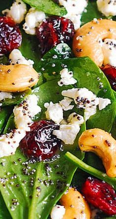 spinach salad with oranges, cranberries and feta cheese on top