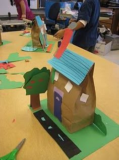 children are making paper houses on the table