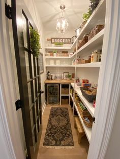 a narrow pantry with open shelving and hanging lights