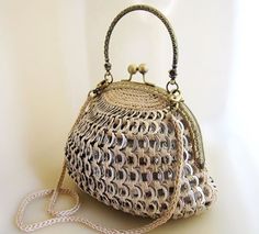 the purse is made out of woven material and sits on a white surface with a chain attached to it