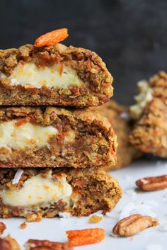 three cookies stacked on top of each other with white frosting and nuts around them