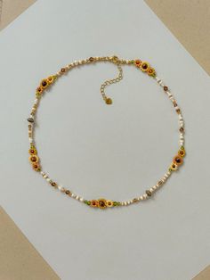 This necklace features different shades of hand woven yellow sunflowers and fall colors of cream, brown, green, and gold. 

Length: 16.5- 19inches

Seed Bead Size: 11/0, 6/0

This dainty piece is made up of high quality seed beads including 24kt gold plated beads, crystals, and tigers eye.

Adjustable: Each necklace has a 2.5” gold filled lobster clasp extender


Strung on: Non-Stretchy Beading Thread
#flowerstagram #sunflower #whimsical #goldjewelryideas #falloutfitideas #autumn #fallfashiontrends #cottagecore Sunflower Beaded Necklace, Autumn Necklace Fall Jewelry, Dainty Diy Jewelry, Aesthetic Bead Necklace, Whimsical Beaded Jewelry, Fall Beaded Jewelry, Sunflower Beaded Bracelet, Seed Bead Necklace Ideas, Seed Bead Flower Necklace