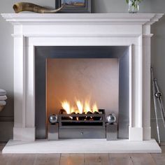 a white fireplace with fire burning in it