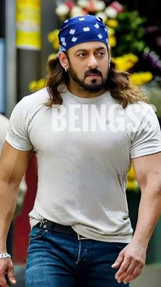 a man with long hair wearing a bandana on his head and looking at the camera