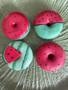 three doughnuts with different designs on them sitting on a paper plate in the shape of a donut