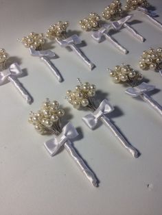 a bunch of pins with bows and pearls on them