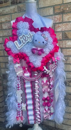 a hello kitty themed dress made out of ribbons and hair clips on a mannequin