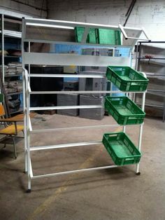 several green bins are stacked on top of each other in a warehouse with metal racks