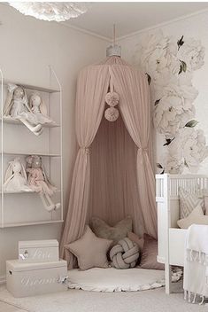 a baby's room with a canopy bed, crib and stuffed animals on shelves