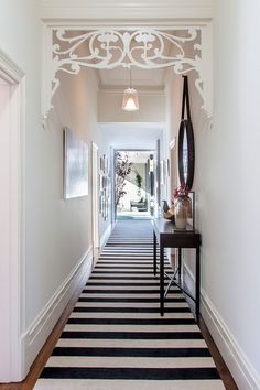 a hallway with a black and white striped rug