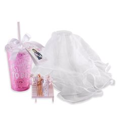 a pink plastic cup with a white veil on it and a doll next to it