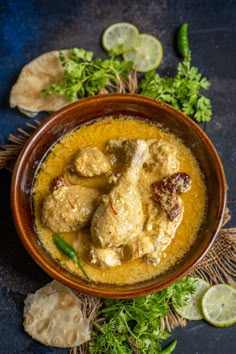 a bowl filled with chicken curry and garnished with cilantro, parsley