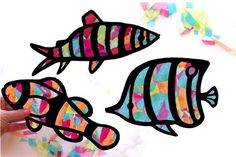 two fish made out of colored paper on a white background