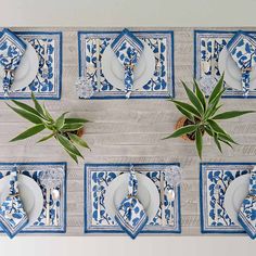 blue and white place settings with plants on them