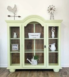 a green china cabinet sitting on top of a hard wood floor