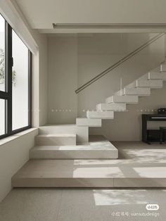 an empty room with stairs leading up to the second floor and a piano on the other side