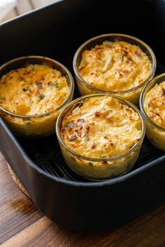 four small cups filled with food on top of a wooden table