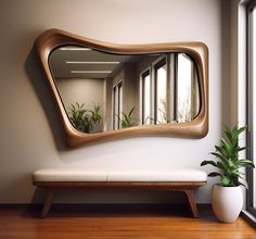 a wooden bench sitting next to a large mirror on the side of a wall in front of a window