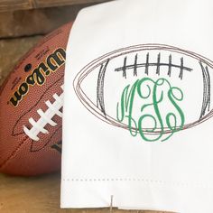 a football and monogrammed napkins are sitting on a table