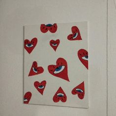 a white wall with red hearts and blue eyes on it's side, next to a sticker