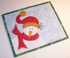 a quilted snowman with a red hat and scarf