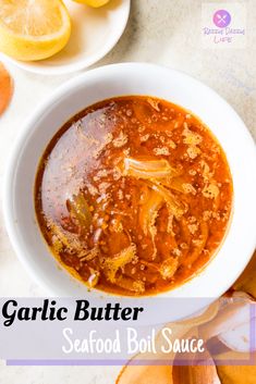 garlic butter seafood bouil sauce in a white bowl next to sliced oranges and lemons