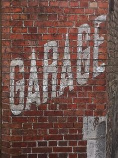 an old brick wall with the word garage painted on it