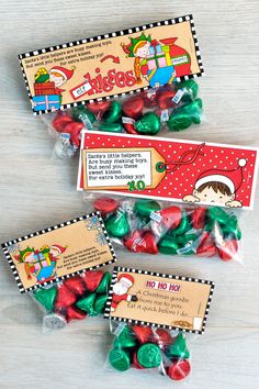 three candy bags filled with christmas candies on top of a wooden table