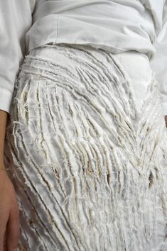 a close up of a person's pants with white yarn on it and the bottom part of their pants