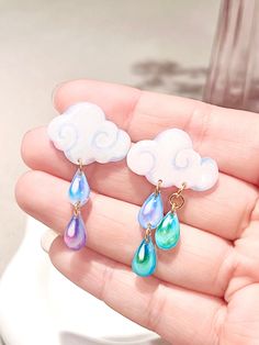 🌧️Multicolor cloud & raindrop earrings, handmade with shrink plastic and UV resin. Each cloud has several raindrops hanging under it, both the cloud and raindrops are hand-drawn with colored pencils, and have a layer of hard clear resin applied on the surface, to create a hard glossy surface. The earring accessories used are sterling 925 silver hypoallergenic earring studs. 🌧️Main Material: Shrink Plastic, UV resin, 925 silver earring studs.  🌧️Size: 40mm*23mm (see size annotation in picture) Earrings Aesthetic, Colorful Clouds, Multicolor Earrings, 925 Silver Earrings, Hypoallergenic Earrings, Accessories Earrings, Silver Earrings Studs, Earrings Handmade, Cute Gifts