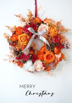 a merry christmas wreath with flowers and pine cones