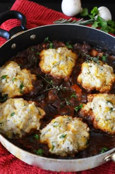 a pan filled with meatballs covered in gravy and garnished with parsley