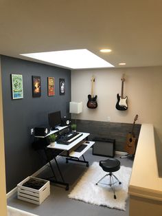 a room with guitars and desks on the wall