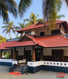 a house with red tile roofing and palm trees in the foreground, on a sunny day