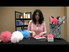 a woman sitting at a table with some decorations on top of it and scissors in front of her