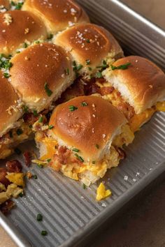 several breakfast sandwiches cut in half on a pan