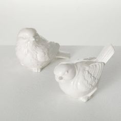 two white ceramic birds sitting next to each other