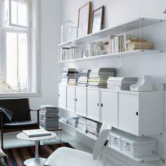 a living room filled with lots of furniture and bookshelves on top of shelves