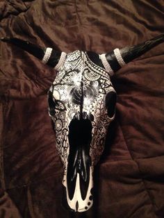 a cow's skull is adorned with black and white lace on a brown background