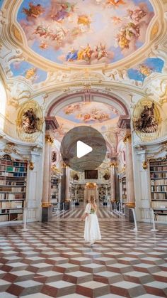 a woman is standing in the middle of a room with bookshelves and ceilings