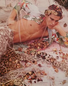 a man laying on top of a bed covered in lots of nuts next to a leopard