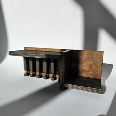 a wooden table with four candles in it and a shadow on the wall behind it