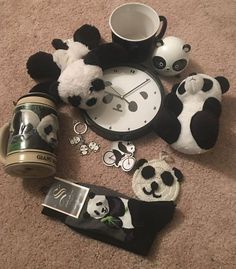 stuffed pandas and other items on the floor next to a coffee cup, alarm clock and keychain