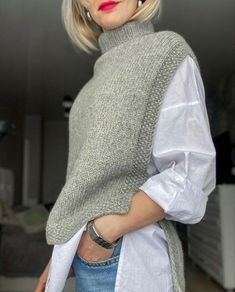 a woman with blonde hair wearing a sweater and jeans