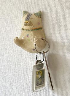 a keychain hanging from the side of a wall with a bear on it