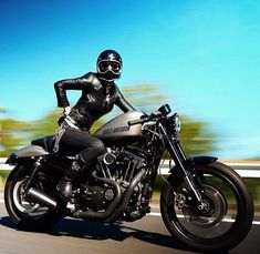 a woman dressed in black riding on the back of a motorcycle