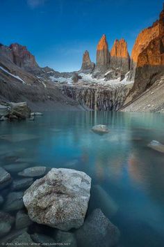 the mountains are covered in snow and blue water