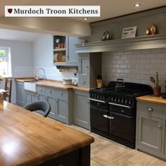 a kitchen with wooden counter tops and gray cabinets