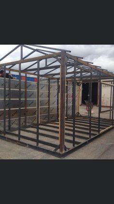 a man standing in the doorway of a building with metal framing on it's sides